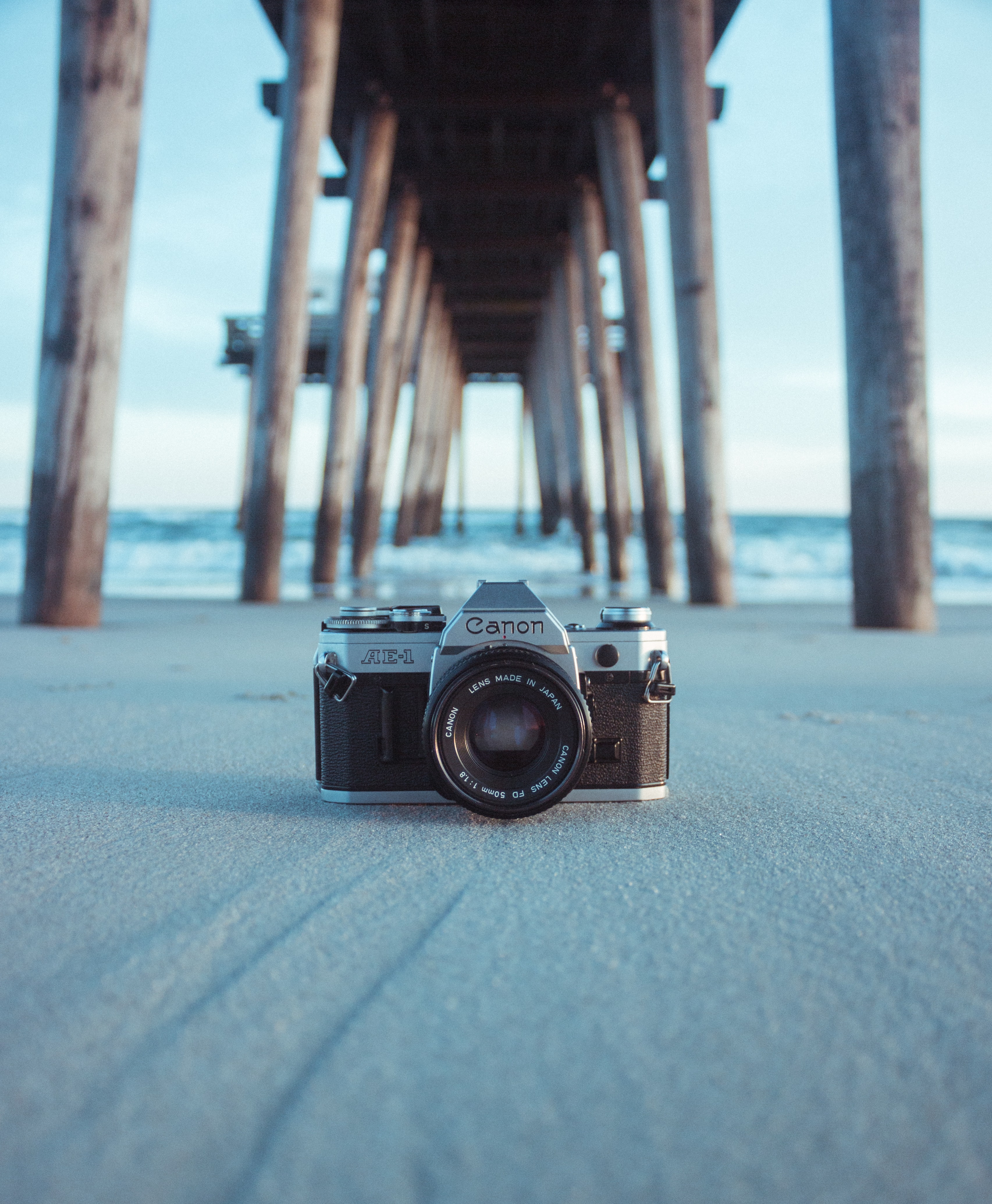 camera on a beach under a pontoon